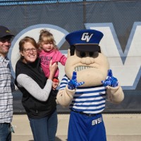 Dad, mom, and daughter smile with Louie